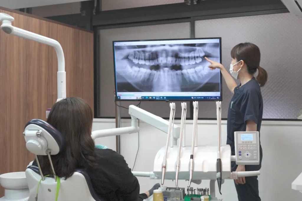 歯科衛生士がレントゲン画像をもとに説明している様子